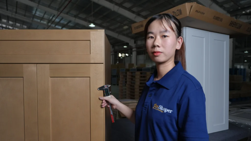 On-site quality control technician measuring finish tolerance and edge banding on cabinet doors at Bloom Cabinetry.