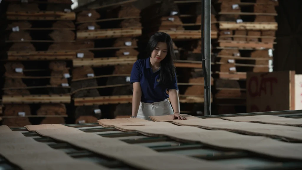 Fiona from theShaper showcasing Red Grandis and Sapele natural wood veneer panels at Kim Cu Thai factory.