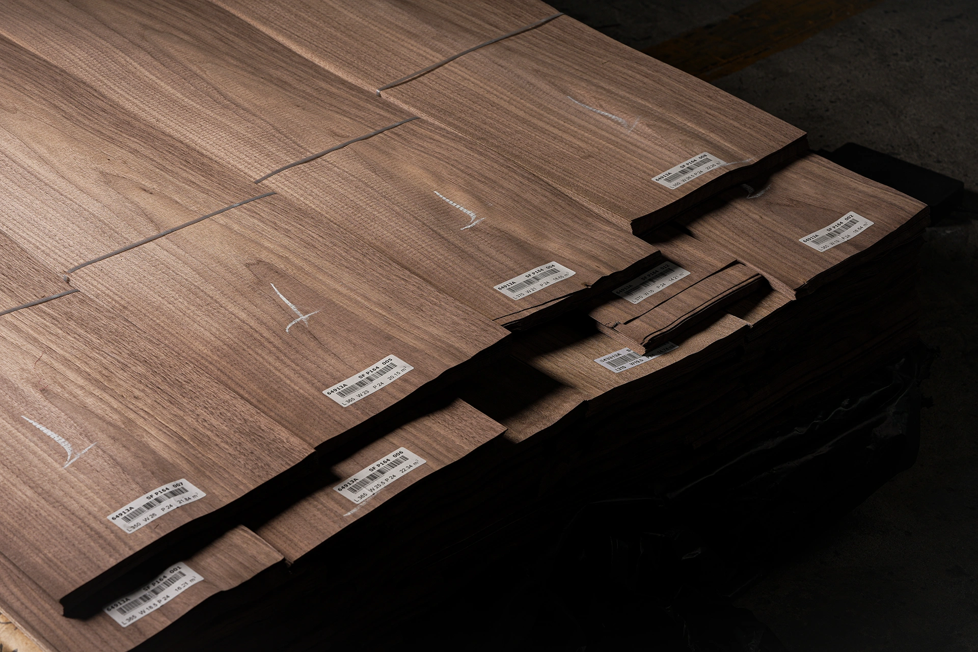 A bundled stack of Crown Cut American Black Walnut veneer sheets marked with quality assurance and specification labels by theShaper.