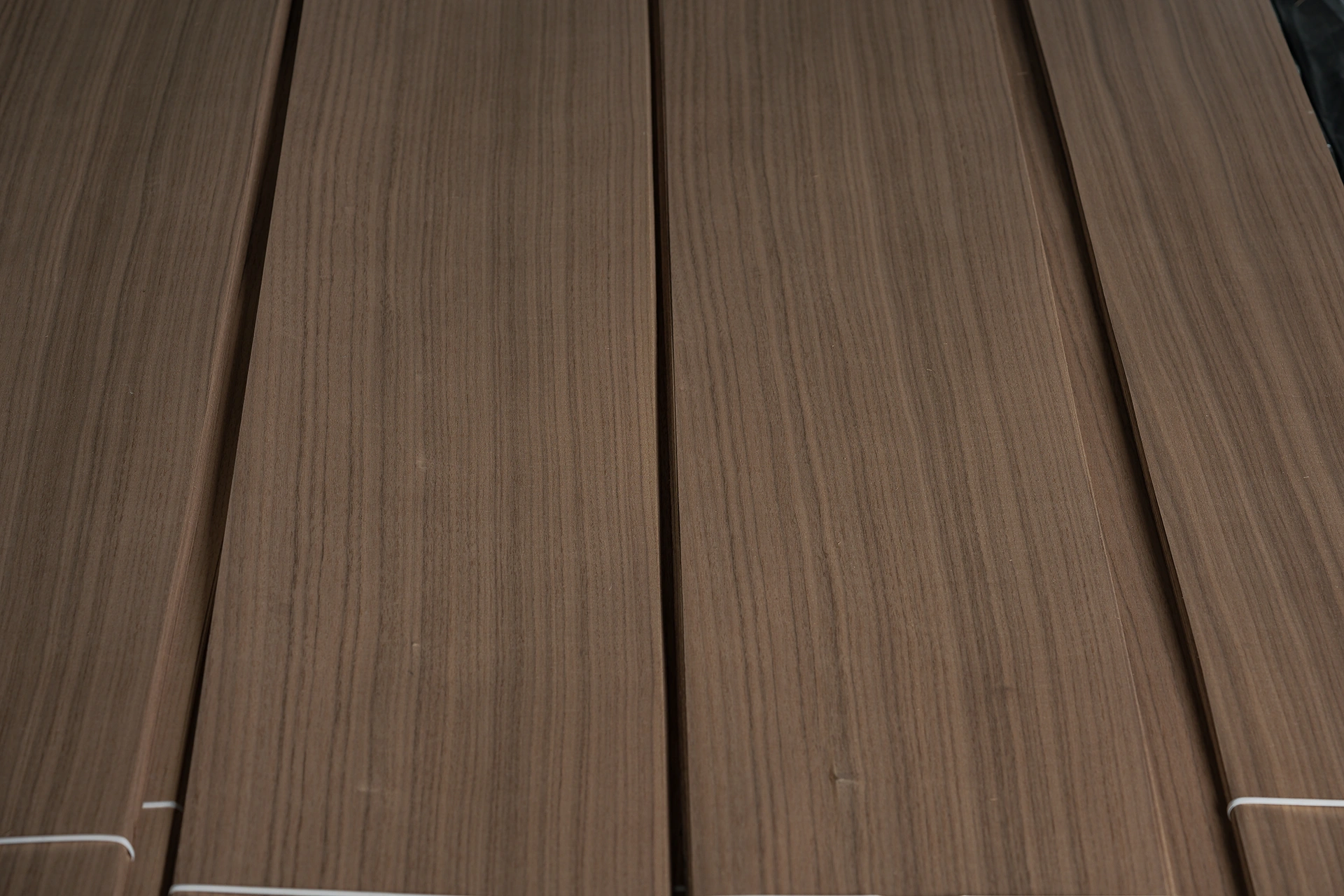 Close-up with shallow depth of field showing the clean Rift Cut Black Walnut veneer linear grain by theShaper.
