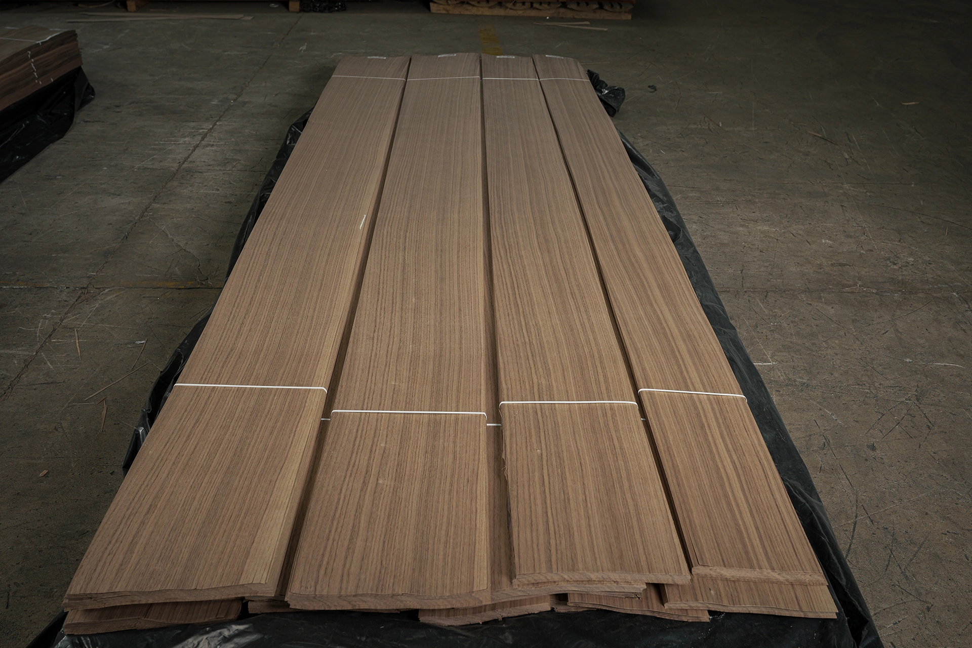 Industrial pallets of premium unspliced American Black Walnut Rift Cut veneer by theShaper, featuring straight linear wood grain.