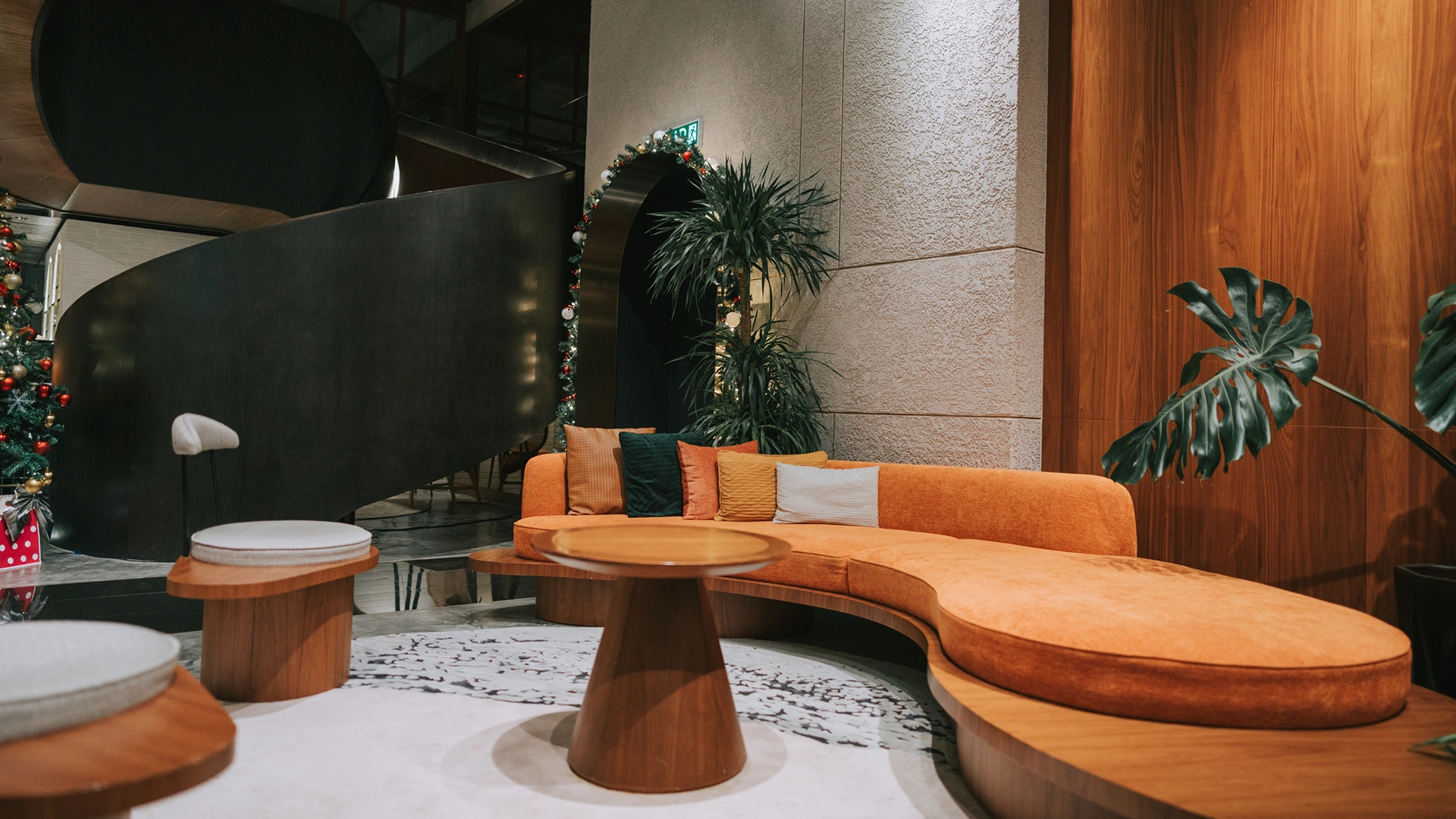 A luxurious hotel reception lobby featuring premium wall decoration crafted from theShaper's crown cut American Black Walnut wood veneer, showcasing rich espresso undertones and majestic, sweeping natural cathedral grain arches.