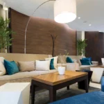 An upscale hotel social lounge featuring custom wall paneling designed with theShaper's crown cut American Black Walnut wood veneer, displaying exquisite deep chocolate tones and striking cathedral patterns that elevate the shared space.