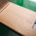 Close-up of a product specification label and FSC certification tag attached to a bundle of Red Grandis quarter cut wood veneer by theShaper.