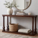 An elegant rustic pine console table styled in a home entryway with decorative accents, highlighting its weathered wood finish and clean lines.