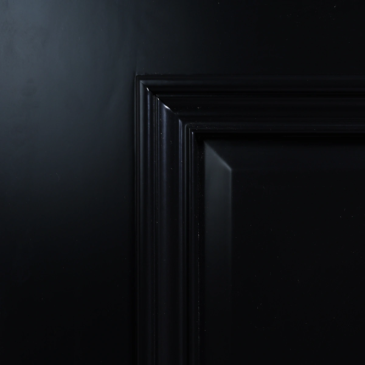 Upper rail and glass frame corner joint on Midnight Iron door