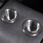 Close-up view of twin recessed stainless steel cup holders in center console.