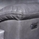 Close-up detail of side power reclining control buttons on arm panel.