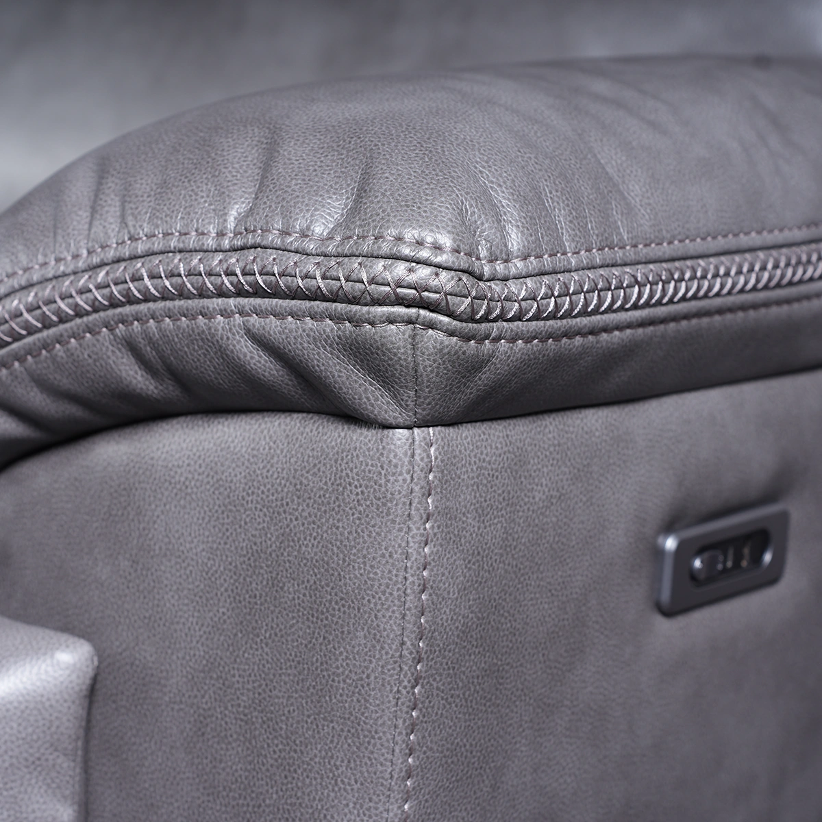 Close-up detail of side power reclining control buttons on arm panel.
