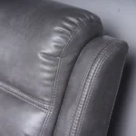 Close-up of tailored precision stitching and textured slate grey faux leather upholstery.