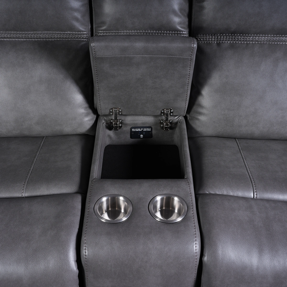 Close-up of open flip-top center storage compartment inside console.
