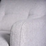 Close-up of slim padded track armrest showing crisp stitching and herringbone weave.