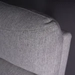 Close-up of ergonomic headrest cushion tailored in light grey herringbone textured fabric.