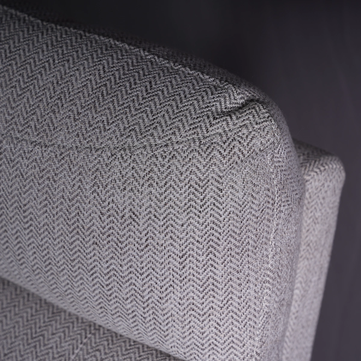 Close-up of ergonomic headrest cushion tailored in light grey herringbone textured fabric.