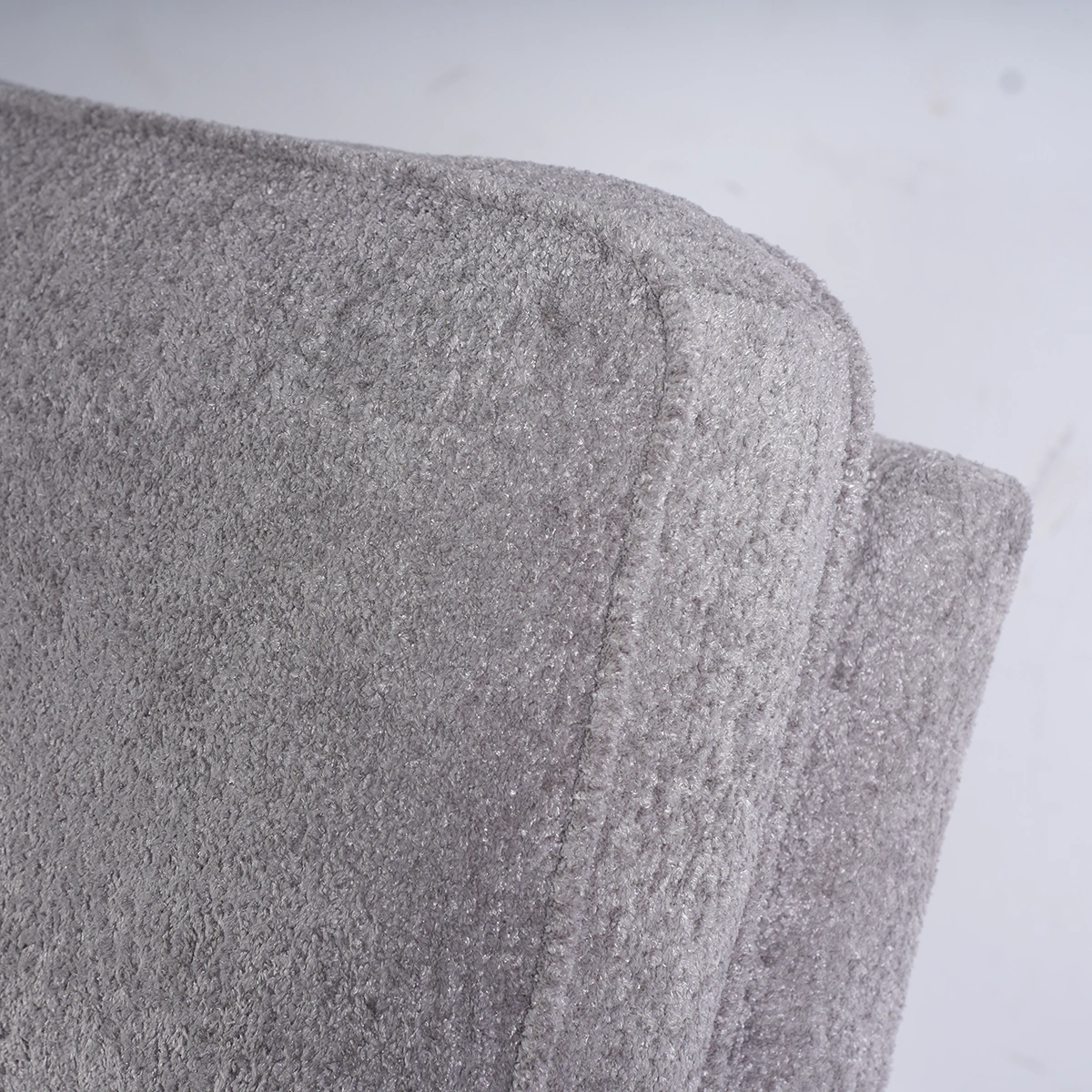 Close-up of ergonomic plush backrest cushion tailored in light grey textured fabric.