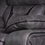 Close-up detail of sporty ergonomic plush pillow-top armrest with durable vintage faux leather stitching.