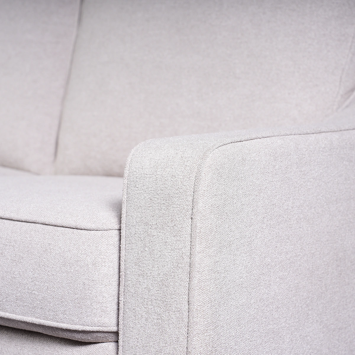 Close-up detail of padded armrest showing premium woven fabric texture and stitching.