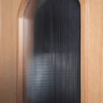 Close-up of vertical fluted reeded glass integrated into the Roman arch Nordic Wheat Oak door frame