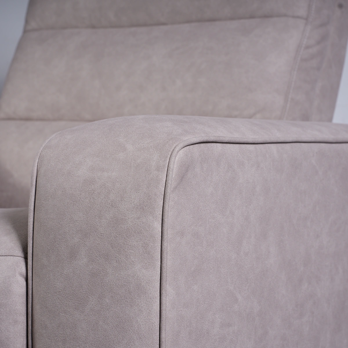 Close-up of modern architectural wide track arm showing tailored stitching and suede-feel eco-leather.