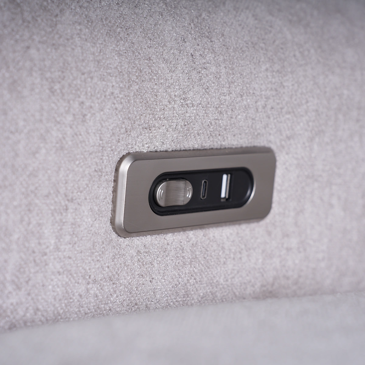 Close-up of brushed metal power recline toggle buttons with integrated USB-A and USB Type-C ports.