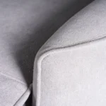 Close-up of tailored piped edge trim along the gently arched padded armrest.